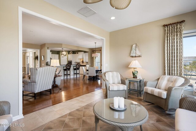 living area featuring recessed lighting, light tile patterned flooring, and visible vents