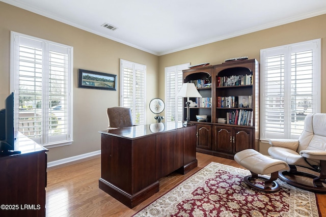 office space with crown molding, baseboards, visible vents, and light wood-style floors