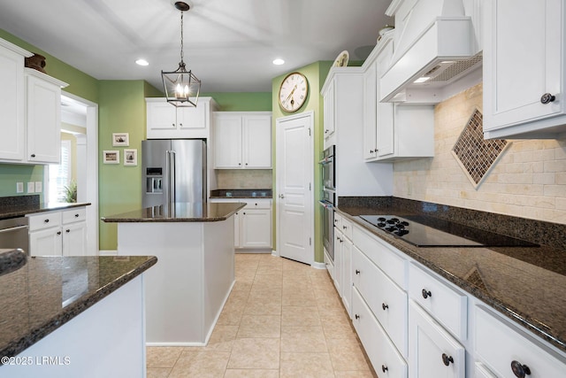 kitchen featuring custom exhaust hood, white cabinetry, appliances with stainless steel finishes, and dark stone countertops