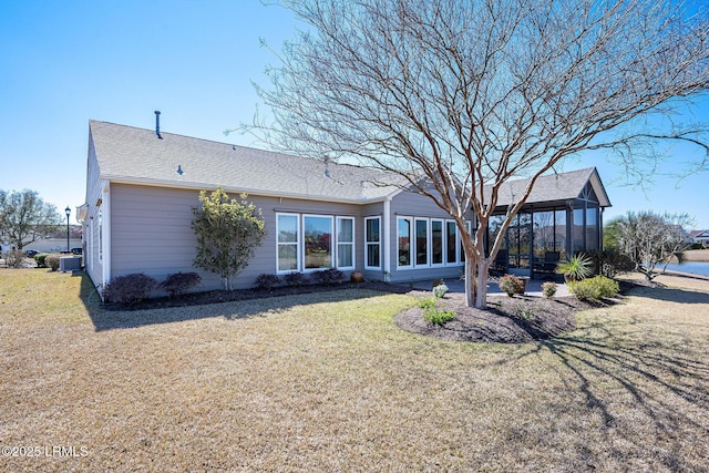 rear view of property with a patio area, a shingled roof, and a lawn