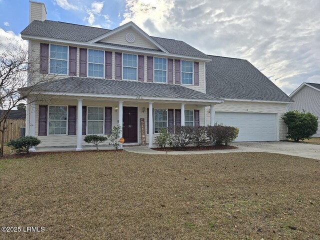 view of front of house with covered porch, a front lawn, and a garage