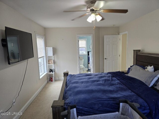 carpeted bedroom with multiple windows, ensuite bath, and ceiling fan