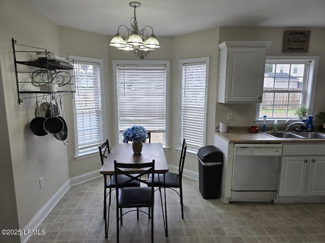 dining space featuring sink and a notable chandelier