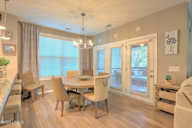 dining room featuring an inviting chandelier, plenty of natural light, and light hardwood / wood-style floors