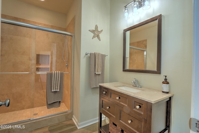 bathroom with vanity, a shower with shower door, and wood-type flooring