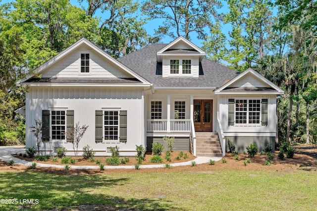 view of front of house featuring roof with shingles, a porch, french doors, and a front yard