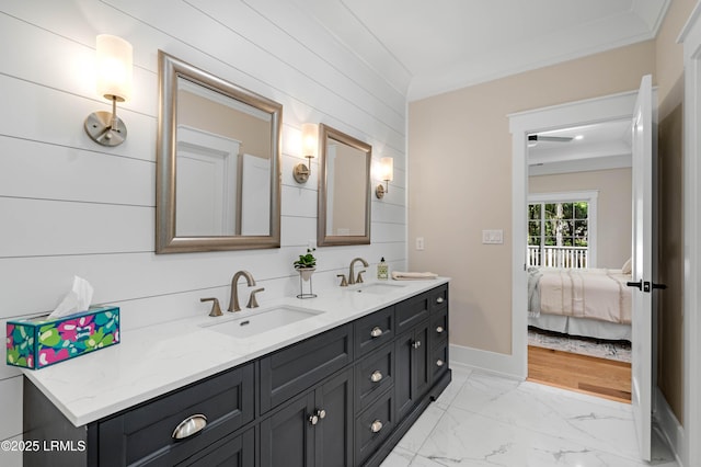 ensuite bathroom with a sink, baseboards, double vanity, and marble finish floor