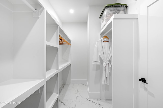 walk in closet with marble finish floor