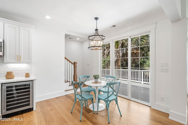 dining area with stairs, baseboards, beverage cooler, light wood-style floors, and recessed lighting