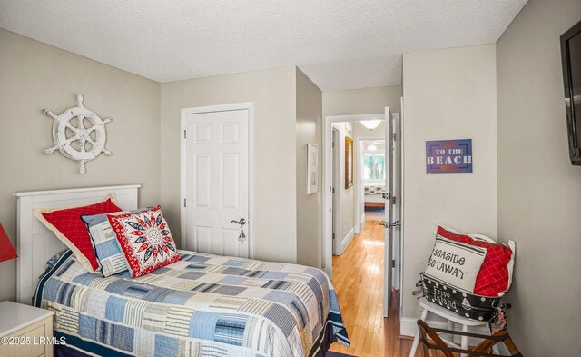 bedroom featuring wood-type flooring and a textured ceiling