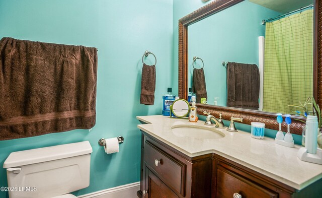 bathroom with vanity, curtained shower, and toilet