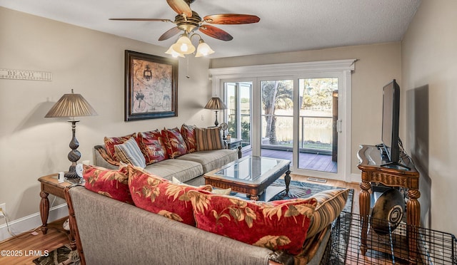 living room with hardwood / wood-style flooring, a textured ceiling, and ceiling fan