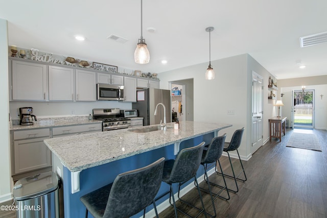 156 Teal Bluff Blvd, Seabrook, SC 29940 - kitchen featuring appliances with stainless steel finishes, a sink, dark wood-style flooring, a breakfast bar, and recessed lighting