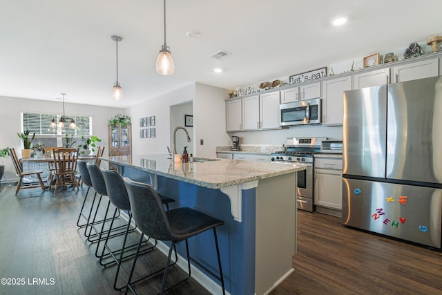 156 Teal Bluff Blvd, Seabrook, SC 29940 - kitchen featuring appliances with stainless steel finishes, a sink, dark wood finished floors, a kitchen bar, and recessed lighting