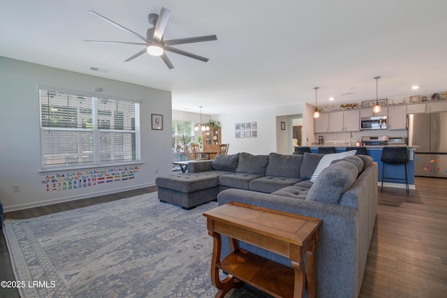 156 Teal Bluff Blvd, Seabrook, SC 29940 - living room featuring dark wood-style floors, ceiling fan, a chandelier, and baseboards