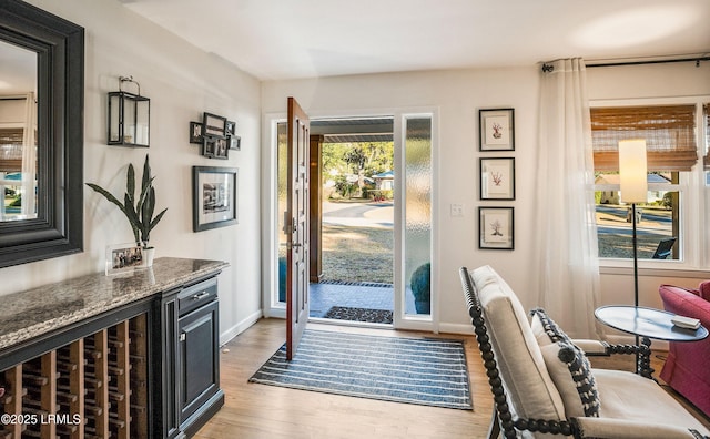 doorway with light hardwood / wood-style floors and beverage cooler