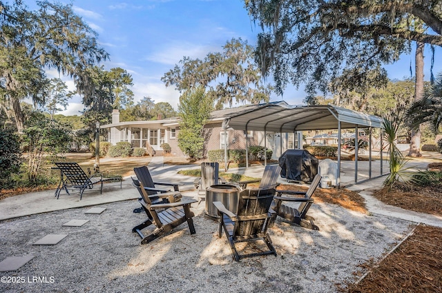 view of patio / terrace featuring a carport, a grill, and a fire pit