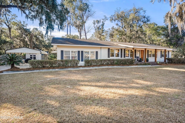 ranch-style house featuring a carport, a front yard, and covered porch