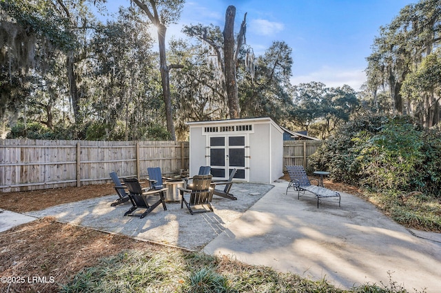 view of patio featuring a shed and an outdoor fire pit