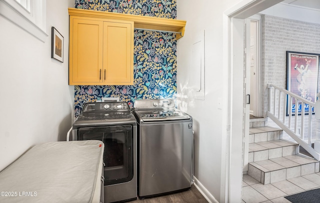 laundry room featuring washer and clothes dryer and cabinets