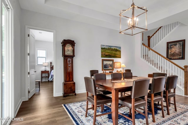 dining space with dark hardwood / wood-style flooring and an inviting chandelier