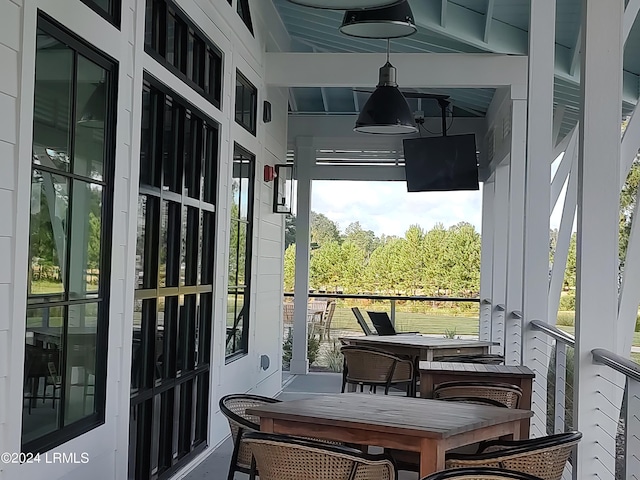 sunroom / solarium featuring a healthy amount of sunlight and beam ceiling