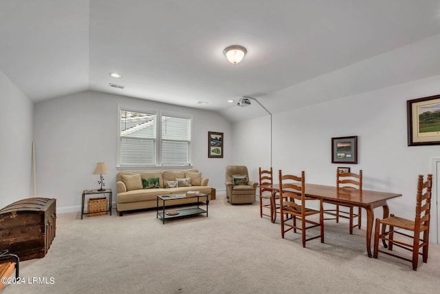 carpeted dining space featuring vaulted ceiling