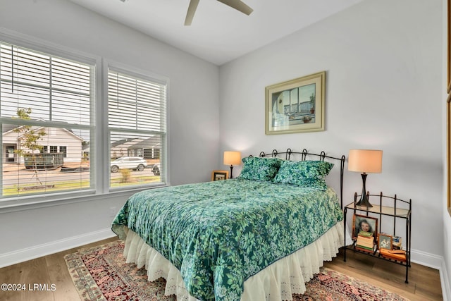 bedroom featuring multiple windows, hardwood / wood-style floors, and ceiling fan