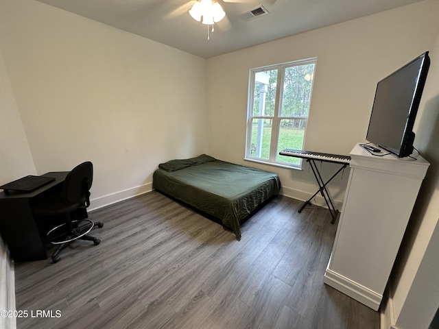 bedroom featuring baseboards, visible vents, ceiling fan, and wood finished floors