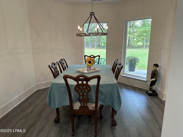 dining space with dark wood-style floors, a wealth of natural light, a chandelier, and baseboards