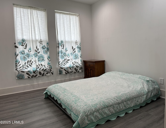 bedroom with dark wood-style flooring and baseboards