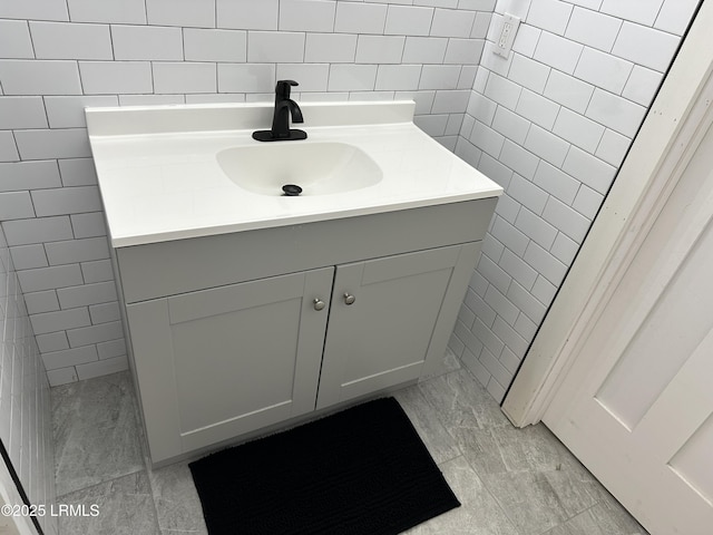 bathroom featuring vanity and tile walls