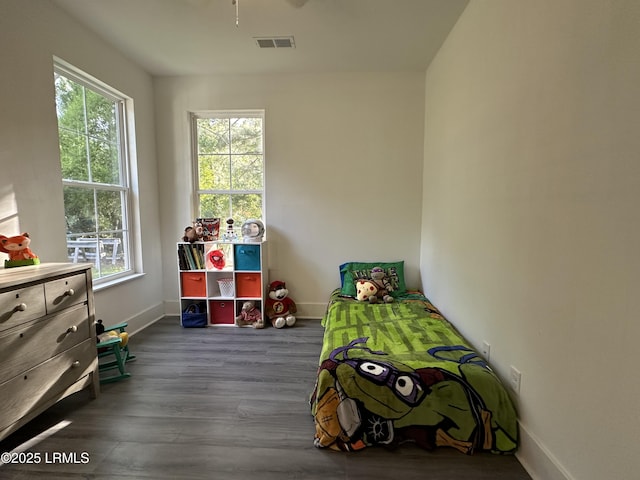 bedroom with visible vents, baseboards, and wood finished floors