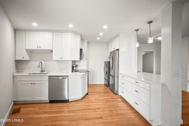 1203 Laudonniere St, Beaufort, SC 29902 - kitchen with appliances with stainless steel finishes, light wood-style floors, white cabinets, and recessed lighting