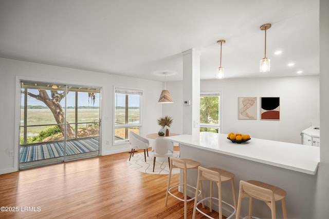1203 Laudonniere St, Beaufort, SC 29902 - kitchen featuring light wood finished floors, a kitchen breakfast bar, light countertops, pendant lighting, and recessed lighting