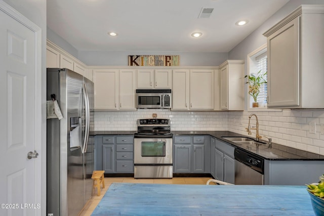 kitchen featuring stainless steel appliances, light tile patterned flooring, sink, and gray cabinets