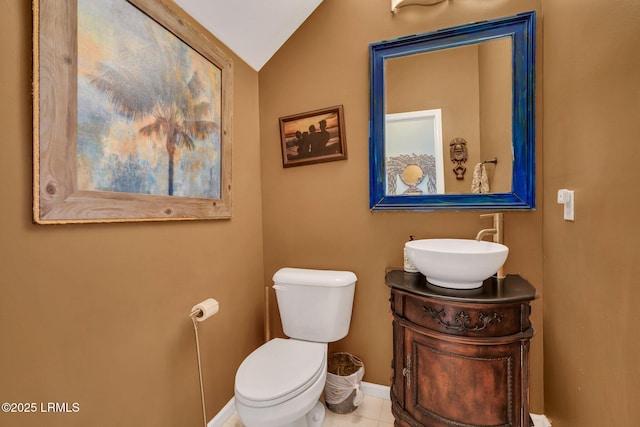 bathroom with lofted ceiling, vanity, tile patterned floors, and toilet