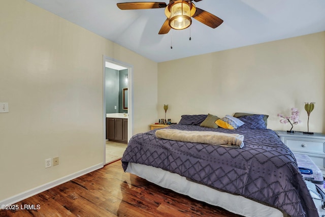 bedroom with hardwood / wood-style floors, ceiling fan, and ensuite bath