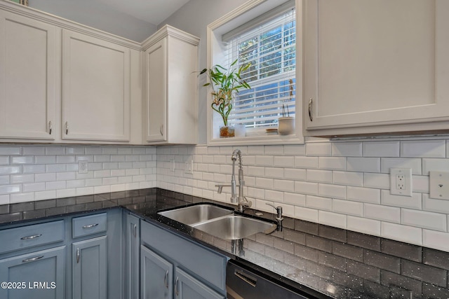 kitchen featuring tasteful backsplash, sink, and white cabinets