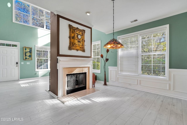 unfurnished living room featuring a high end fireplace and light hardwood / wood-style flooring