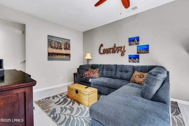 living room with ceiling fan and light hardwood / wood-style flooring