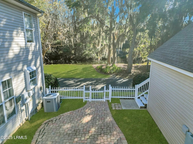 view of yard with central AC and a patio