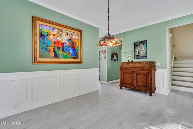 dining space with crown molding and light wood-type flooring