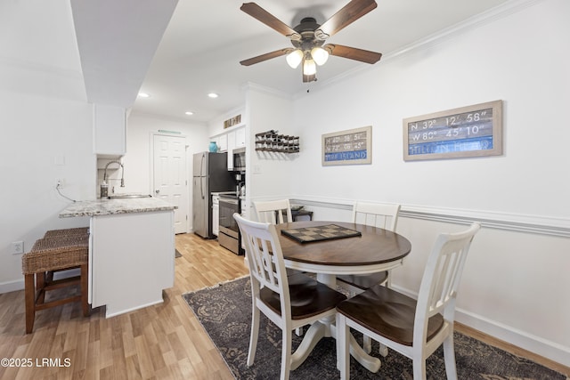 dining room with crown molding, recessed lighting, light wood-style flooring, a ceiling fan, and baseboards