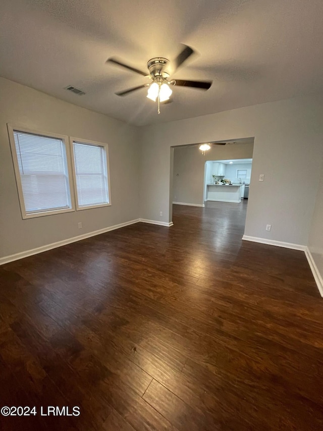 spare room with dark hardwood / wood-style floors, a textured ceiling, and ceiling fan