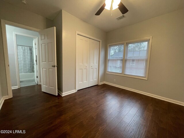 unfurnished bedroom with dark hardwood / wood-style flooring, ceiling fan, and a closet