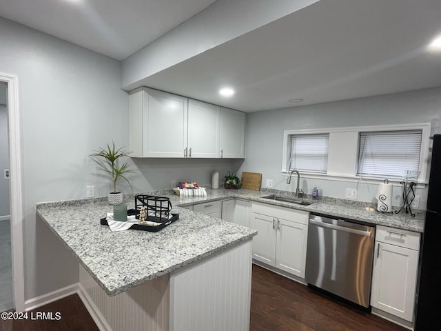 kitchen with sink, stainless steel dishwasher, kitchen peninsula, and white cabinets