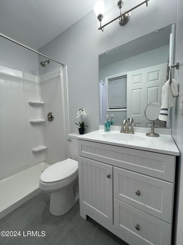 bathroom featuring tile patterned flooring, a shower, vanity, and toilet