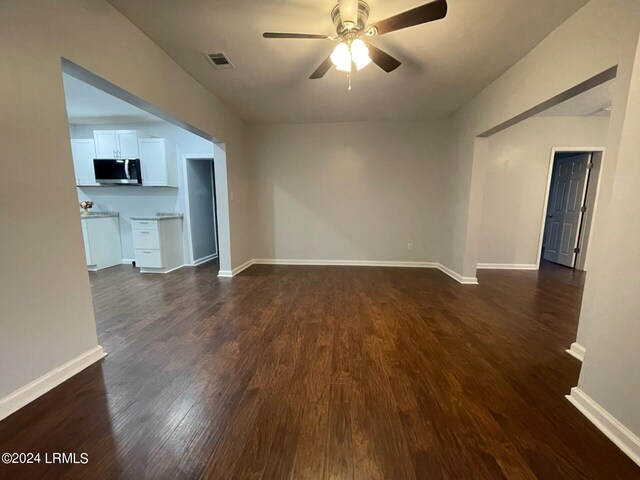 unfurnished living room with ceiling fan and dark hardwood / wood-style flooring