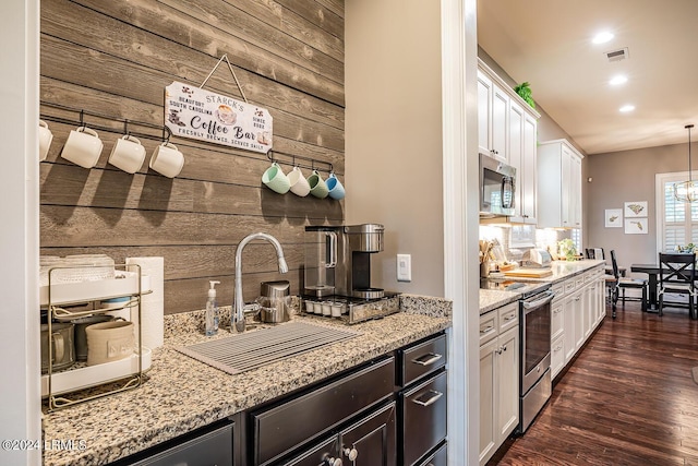 15 Carter Oaks Dr, Beaufort, SC 29907 - kitchen featuring appliances with stainless steel finishes, wood walls, white cabinetry, sink, and light stone countertops